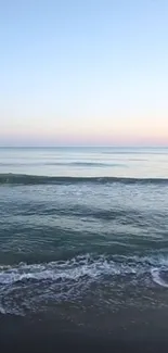 Tranquil ocean view with calm waves and a serene horizon at dusk.