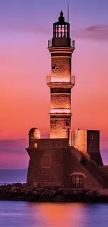 Lighthouse silhouetted against a vivid sunset with purple and orange hues over the ocean.