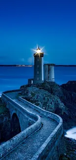 Beautiful lighthouse with ocean views illuminated under a night sky.