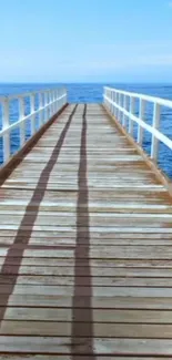 Wooden pier extending over calm ocean under blue skies.