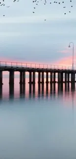 Serene ocean pier at sunset with pastel sky and calm waters.