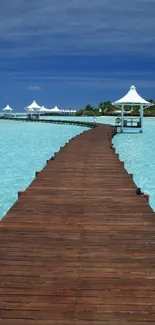 Wooden pier stretches into vibrant blue ocean under a clear sky.