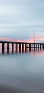 Tranquil pier over calm ocean waters at sunset.