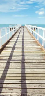 Serene pier leading to the ocean under clear blue skies.