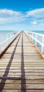 Serene ocean pier with blue skies and calm seas, perfect for mobile wallpaper.