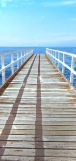 Serene wooden pier extending over a calm blue ocean under a clear sky.