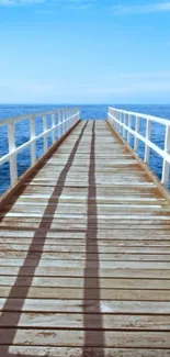 Serene pier overlooking a calm ocean under a bright blue sky.