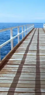 A serene pier extending into the blue ocean under a clear sky.