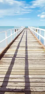 Tranquil ocean pier view with a wooden boardwalk and clear blue sky.