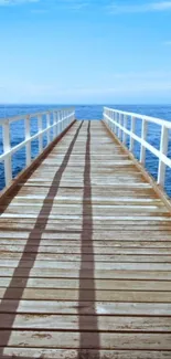 Serene ocean pier with blue sky and wooden boardwalk leading into the sea.