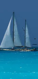 Sailing yacht on turquoise ocean under clear blue sky.