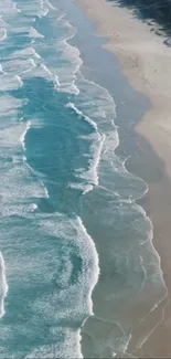 Aerial view of ocean waves hitting a sandy coastline, creating a serene landscape.