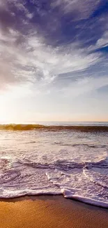 Serene ocean sunset with waves on a beach and vibrant sky hues.