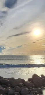 Tranquil sunset over ocean with rocky shore and golden sky.