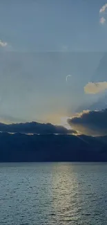 Serene sunset over ocean with clouds and sky.