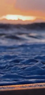 Blue ocean waves at sunset with vibrant sky.