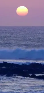 A beautiful ocean sunset with pink and blue hues over the horizon.