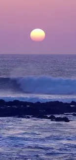 Purple ocean sunset with waves and serene coastal view.