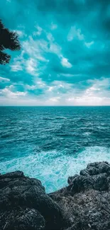 Serene turquoise ocean view with rocky shore and vibrant sky.