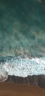 Aerial view of ocean waves meeting sandy beach.