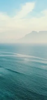 Serene ocean view with distant mountains and clear sky.