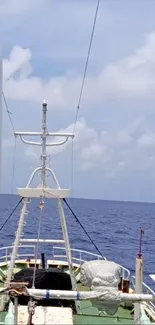 Ship's bow with ocean and cloudy sky in background.