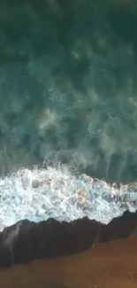 Aerial view of ocean waves crashing gently on a serene sandy beach.