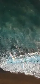 Aerial view of ocean waves crashing on a sandy beach.