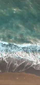 Aerial view of ocean waves gently crashing onto a sandy beach.