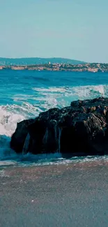 Serene beach with ocean waves and rocks, perfect for mobile wallpaper.