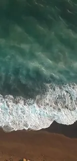 Aerial view of serene ocean waves meeting sandy beach.