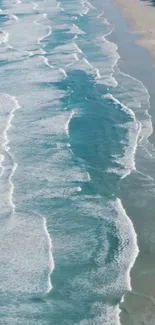 Aerial view of turquoise ocean waves on a sandy beach.