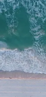 Aerial view of serene ocean waves hitting the shore with aqua blue water and white foam.