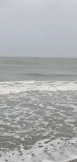 Calm ocean scene with gentle waves and a cloudy sky.