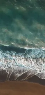 Aerial view of ocean waves meeting sandy shore.