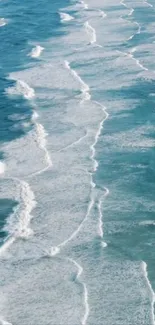 Aerial view of serene ocean waves with frothy white surf.