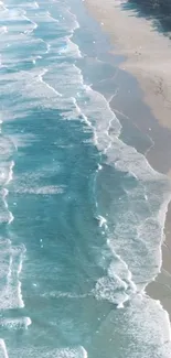 Aerial view of serene ocean waves lapping a sandy beach.