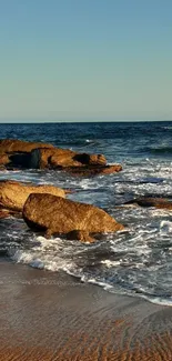 Rocky beach with serene ocean waves at dawn.