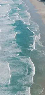 Aerial view of serene ocean waves gently lapping along a sandy coastline.