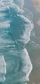 Aerial view of turquoise ocean waves meeting sandy beach.