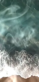 Aerial view of emerald ocean waves crashing on the beach.