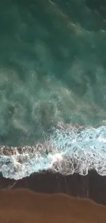 Aerial view of teal ocean waves meeting the dark sandy shore.