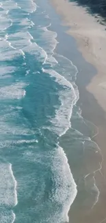 Aerial view of ocean waves meeting a sandy beach.