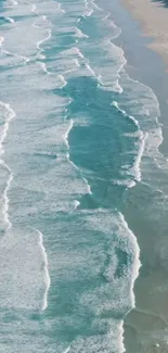 Aerial view of serene ocean waves along a sandy beach.