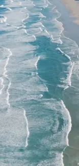 A calming ocean waves wallpaper with white foam and sandy beach.