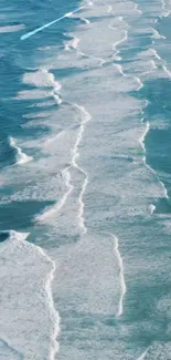 A serene mobile wallpaper of turquoise ocean waves with white foam.