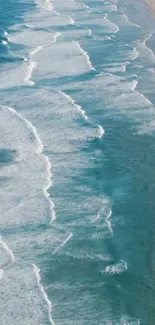 Aerial view of calming ocean waves on sandy beach.