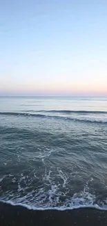 Serene ocean waves with pastel sky and calm blue waters.