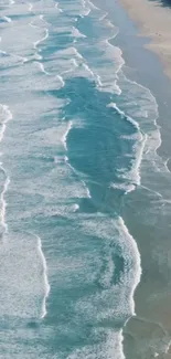 Aerial view of ocean waves on a sandy beach, creating a calming atmosphere.