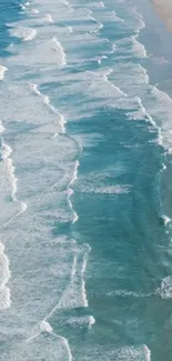 Aerial view of ocean waves creating a serene beach scene in blue tones.